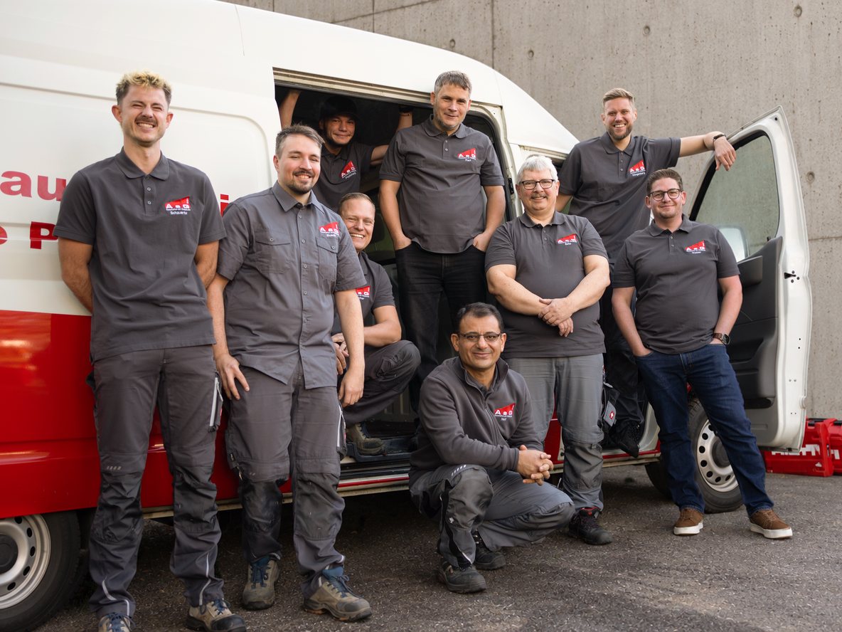 Die Belegschaft der AaG GmbH vor einem Firmenfahrzeug
