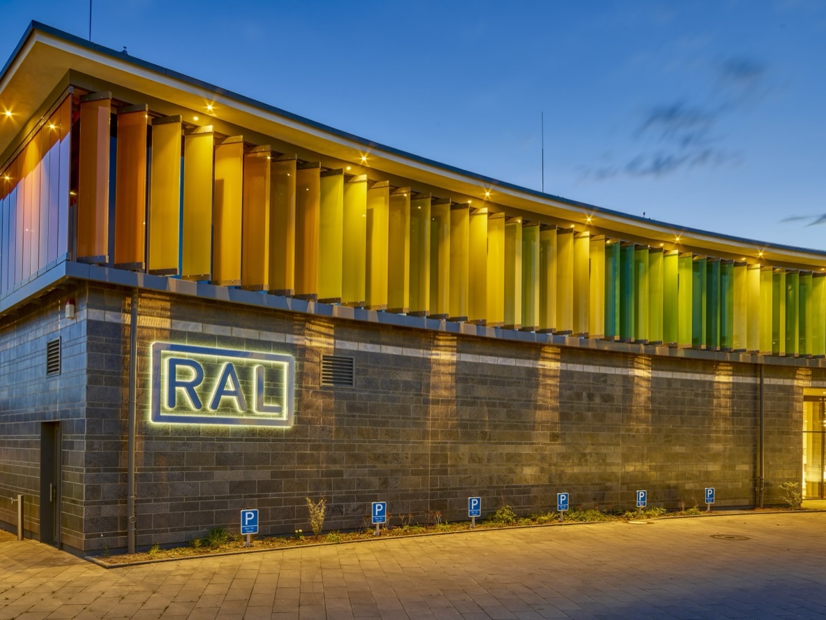 Beleuchtete Fassade des RAL-Neubaus bei Nacht